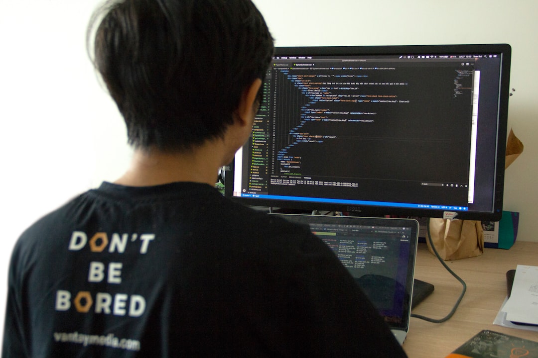 API integration for business - man in black shirt using laptop computer and flat screen monitor