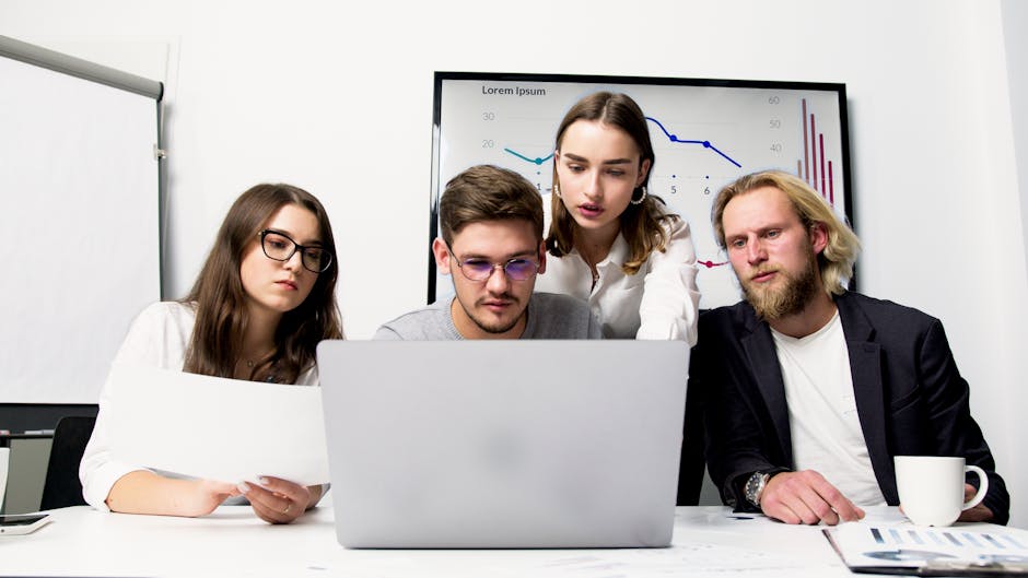 custom software vs off the shelf - Business team engaged in a collaborative meeting using a laptop to discuss strategies.
