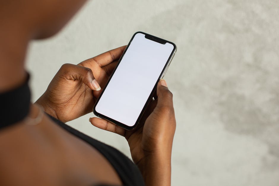 MVP development for startups - Close-up of a woman holding a smartphone with a blank screen, ideal for mock-ups and design.