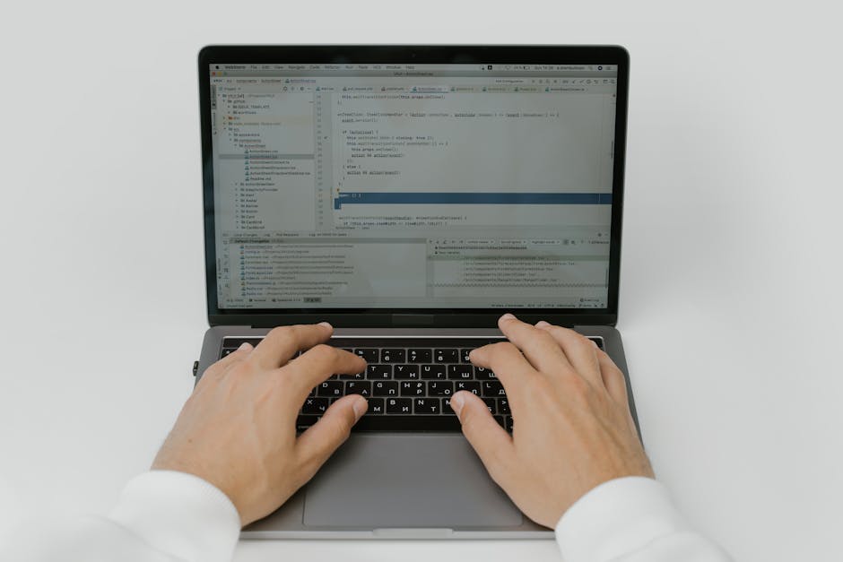 custom apps for small business - Close-up of hands coding on a laptop, showcasing software development in action.