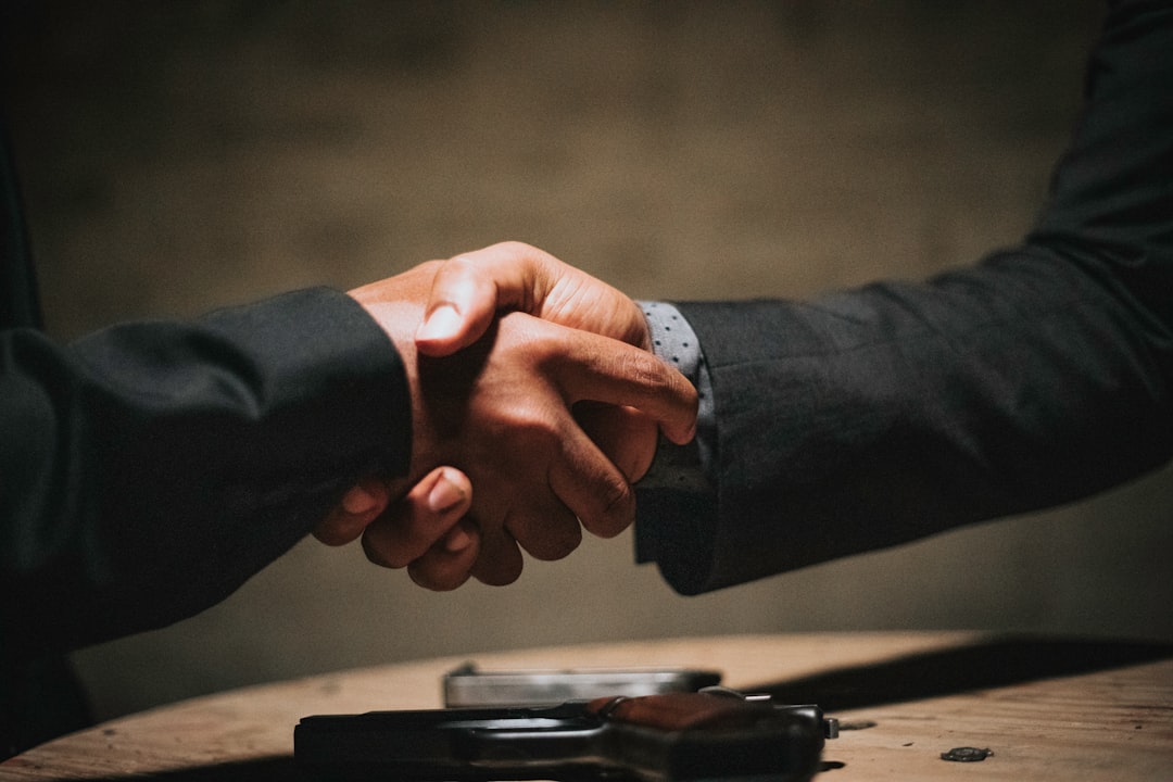 AI startup news - two people shaking hands over a wooden table
